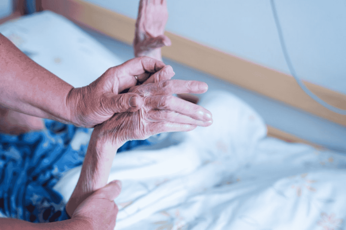 Eine junge Hand hält die Hand einer älteren Person